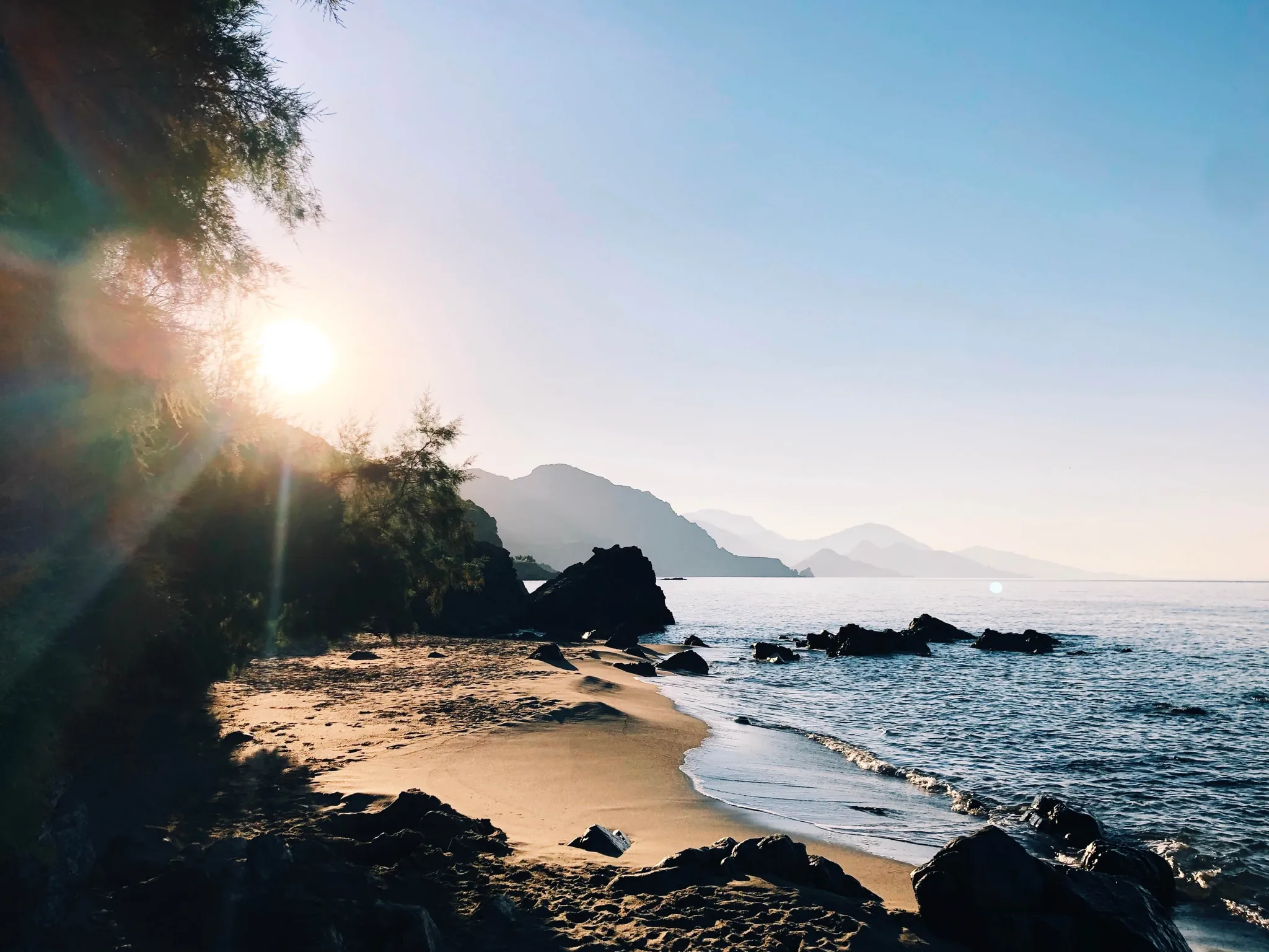 Polyrizos beach at sunset, rocks in the shallows